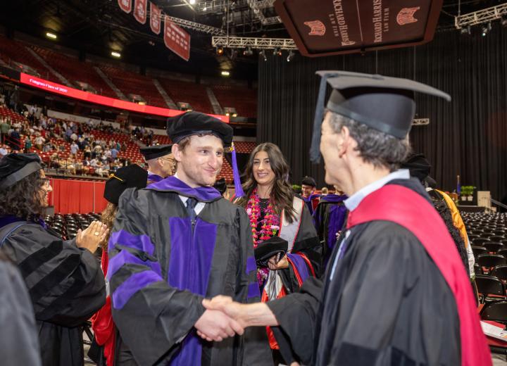 Student graduating and shaking hand
